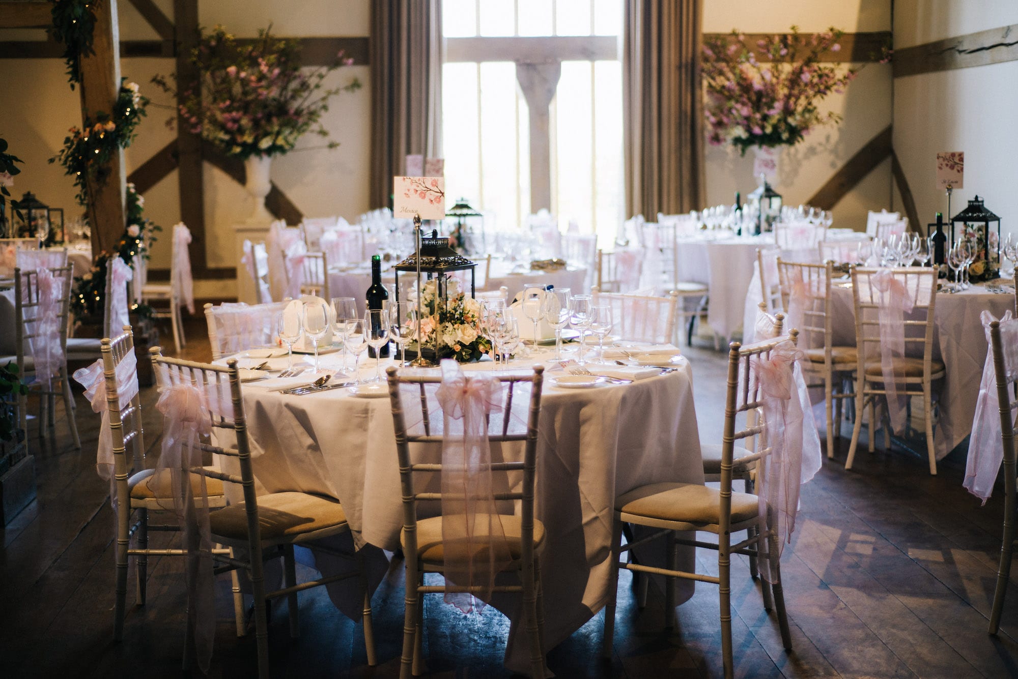 round table wedding breakfast setup with blush pink chair sash covers