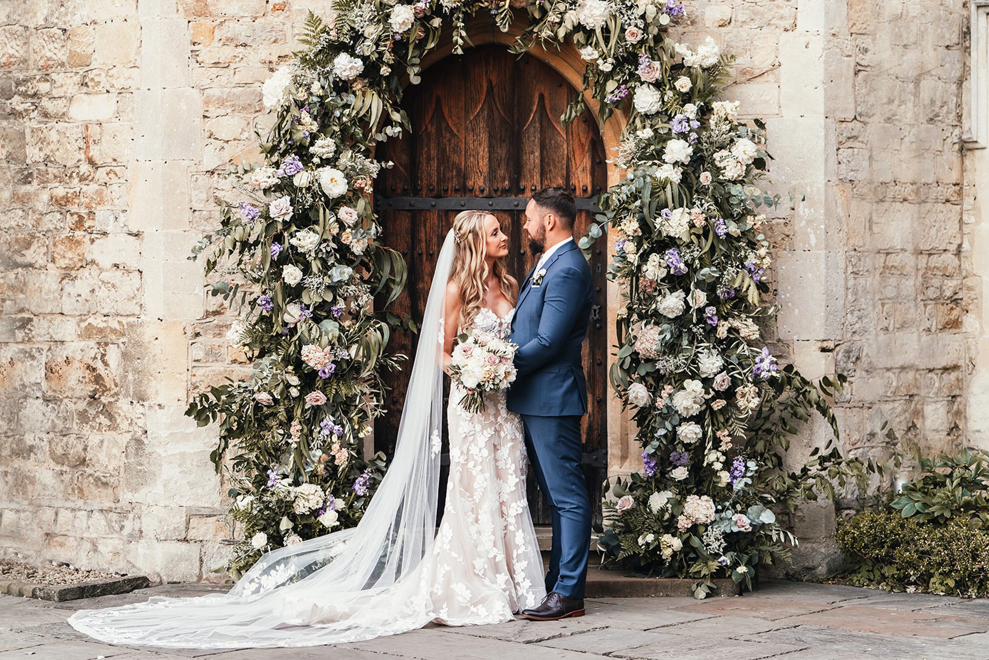 Notley abbey newlyweds under grand floral archway